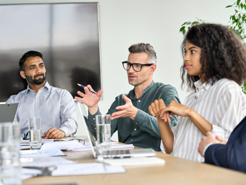 Mature,Mentor,Manager,Speaking,At,Executive,Team,Meeting,In,Boardroom.