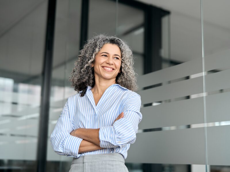 Happy,Mature,Business,Woman,Leader,Standing,In,Office,Looking,Away.